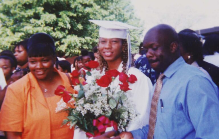 Mother and Father standing with graduate daughter